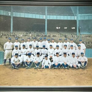Vintage black‑and‑white photo of the 1927 New York Yankees team posing together on the field