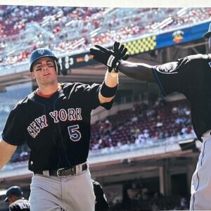 David Wright crosses home plate as Carlos Delgado congratulates him during a Mets game.
