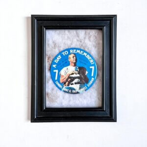 Framed display featuring a silver Mickey Mantle Number 7 pin mounted against a dark background