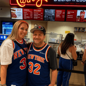 wo New York Knicks fans in blue uniforms posing in msg Carnegie Deli